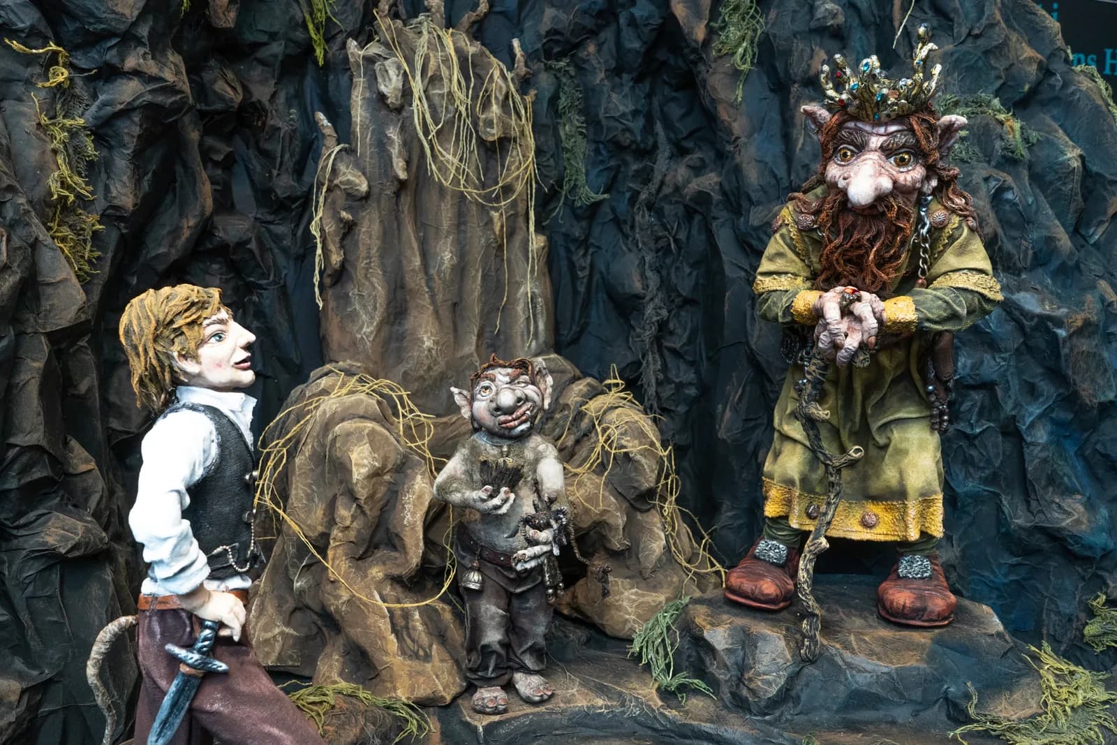 Troll figures of the museum, a boy, a small troll and the old troll king in a mountain scene