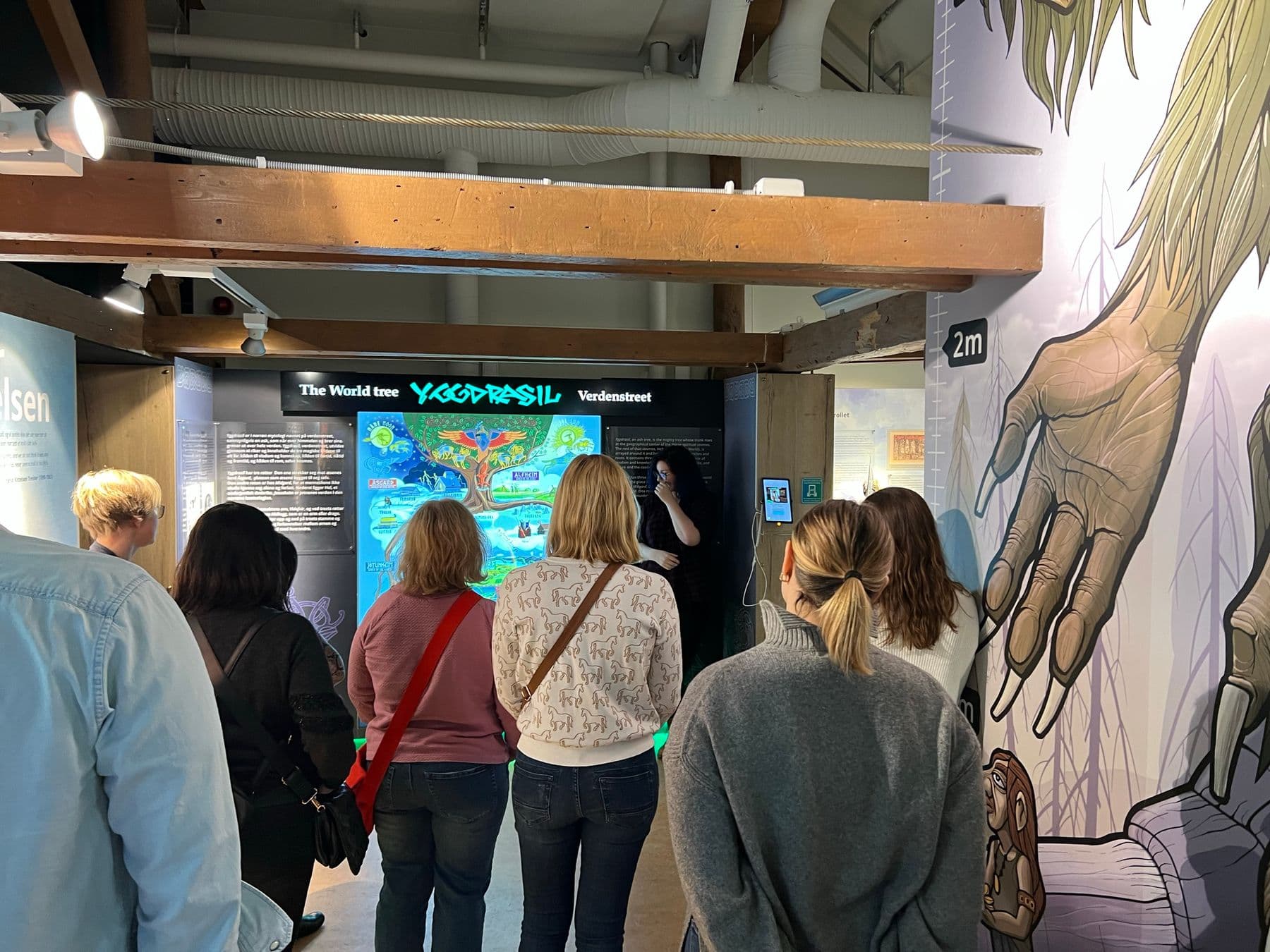 A guided group at the World Tree Yggdrasil exhibit inside Troll Museum Tromsø
